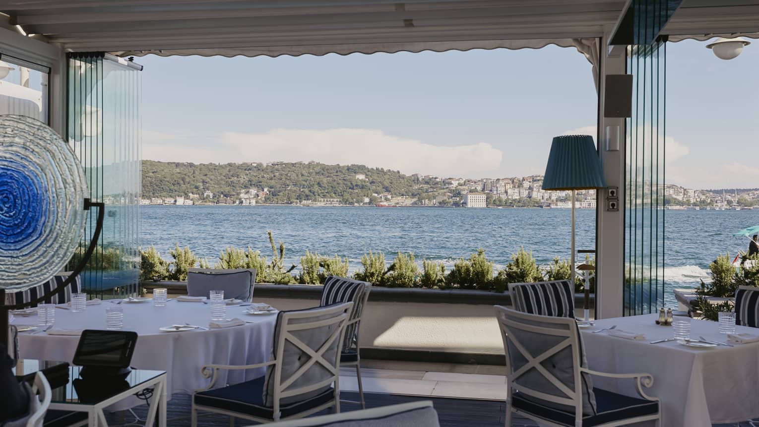 Waterfront restaurant covered terrace with casual tables